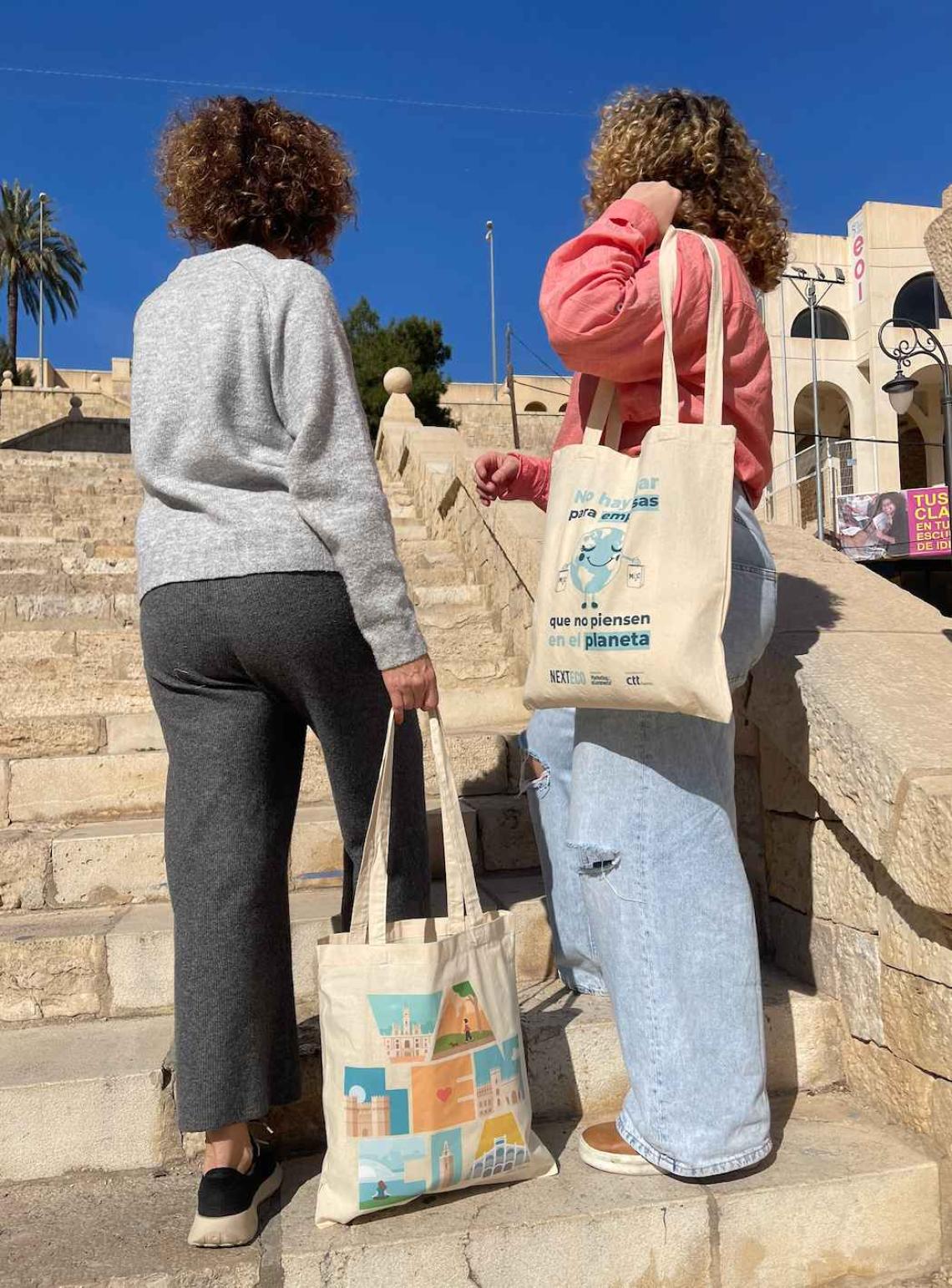 Bolsa de algodón personalizadas con dos mujeres sosteniendo las bolsas