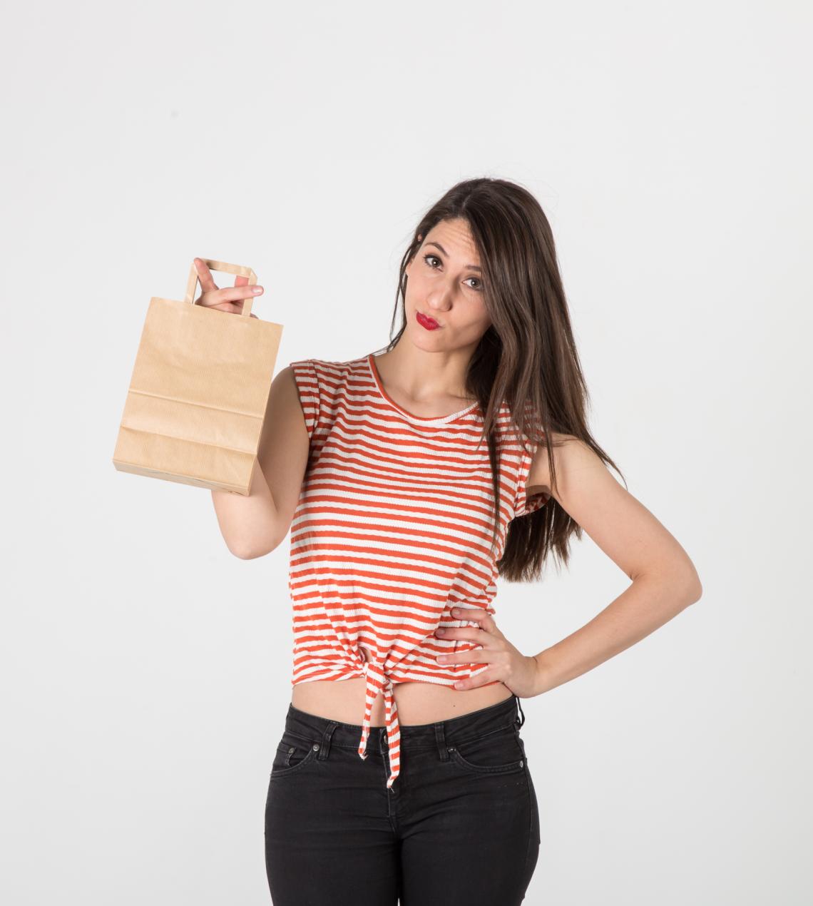 Una mujer sujetando las bolsas de papel de asa plana