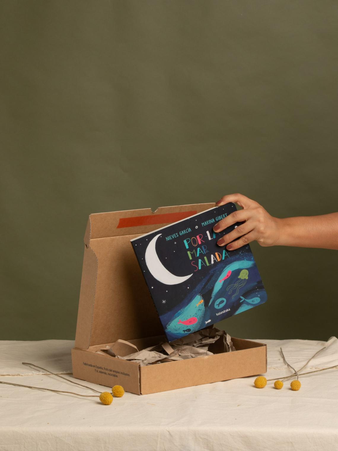 Caja automontable de cartón kraft para envíos sostenibles | Bolsalea Caja automontable de cartón kraft con relleno reciclado y un libro en su interior. Embalaje ecológico y fabricado en España con impacto social por Bolsalea. Si deseas tu caja con separadores interiores, contáctanos.