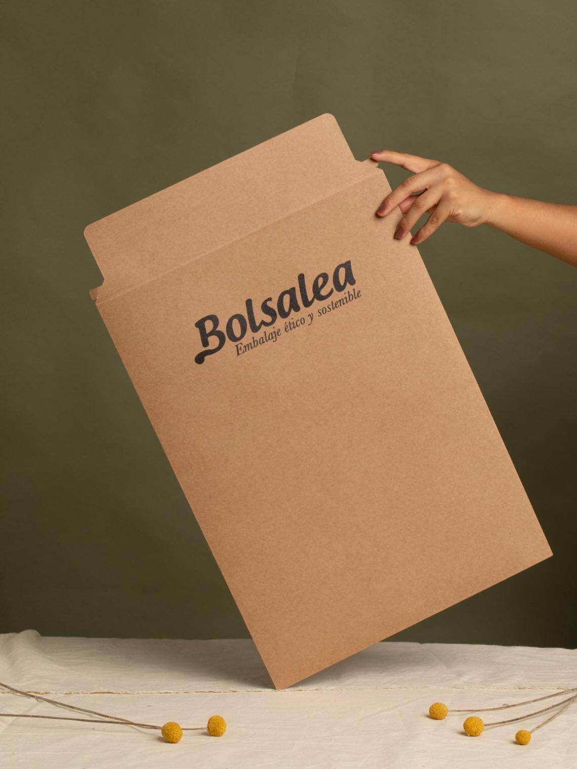 Sobre kraft ecológico tamaño grande | Fabricación con impacto social Mano sosteniendo un sobre kraft grande con el logo de Bolsalea. Embalaje sostenible fabricado en España con empleo inclusivo y materiales reciclables.