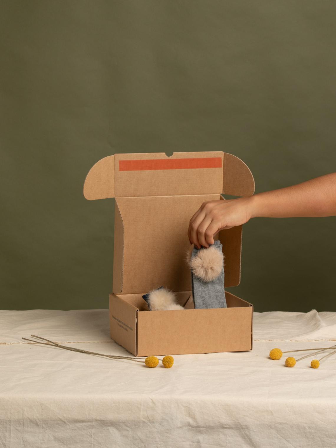 Una mano sacando un producto de la caja ecommerce