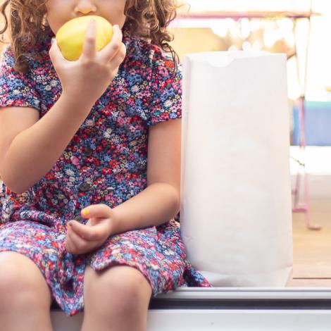Venta de bolsas sin asas Una niña al lado de las bolsas