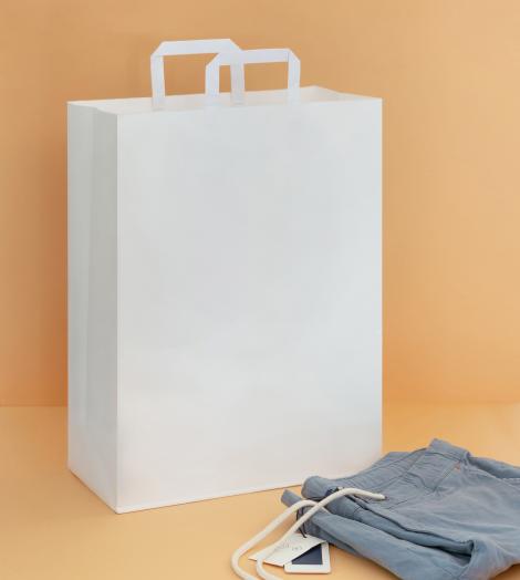 Bolsas de papel de asas planas junto a unas chaquetas