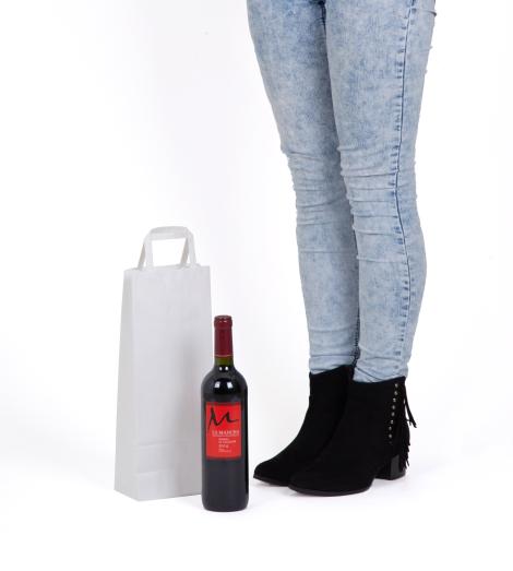 Bolsas de papel que tienen al lado una botella
