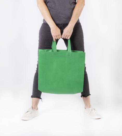 Bolsas verdes con fuelle lateral sujetadas por una mujer