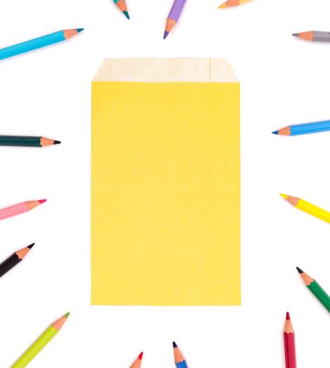 Sobres de papel pequeños con lápices de colores alrededor