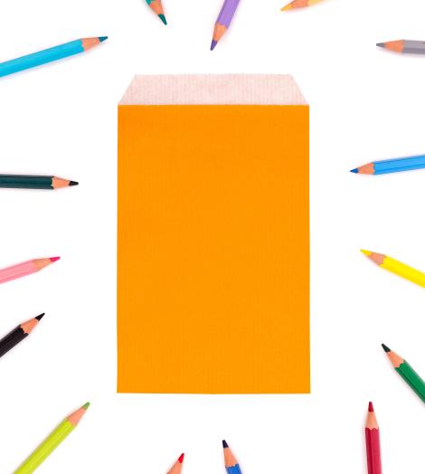 Sobres de papel pequeños con lápices de colores alrededor