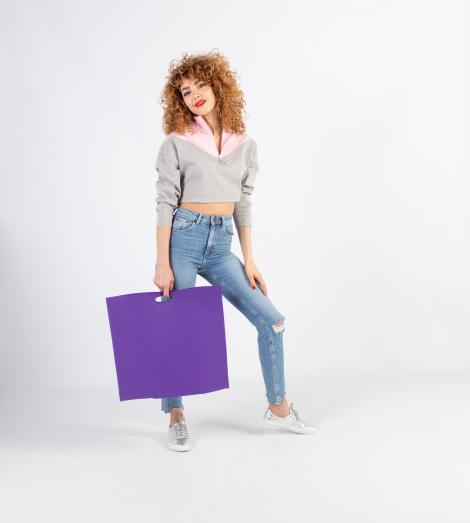Bolsas con asas troqueladas grandes sujetadas por una mujer